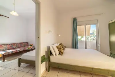 a bedroom with a bed and a sliding glass door at Akti Galinis in Kalyves