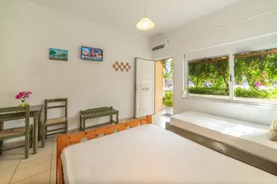 a bedroom with two beds and a table and a window at Akti Galinis in Kalyves