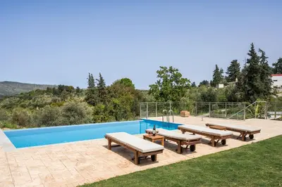 a patio with benches and a swimming pool at Kontis Village in Fílippos
