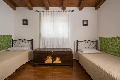 a room with two beds and a window with two teddy bears at Villa Drakona in Keramia