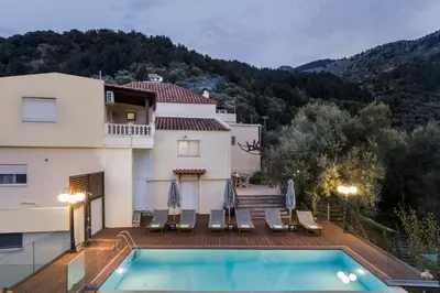 a villa with a swimming pool in front of a house at Villa Drakona in Keramia