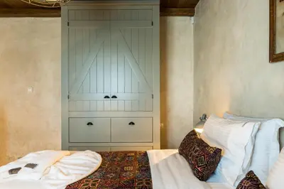 a bedroom with a bed and a cabinet in it at Listen to Nature in a Renovated Traditional Hilltop Villa Liodosifis with Heated Pool in Païdhokhórion
