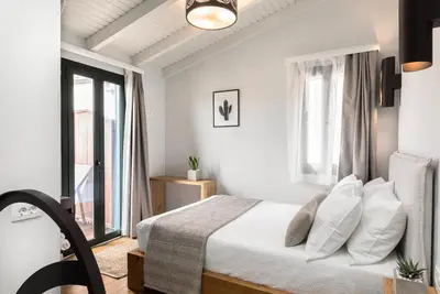 a white bedroom with a bed and a window at Kamares Sanctuaries in Kolymvari