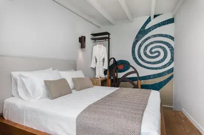 a bedroom with a white bed and a painting on the wall at Kamares Sanctuaries in Kolymvari