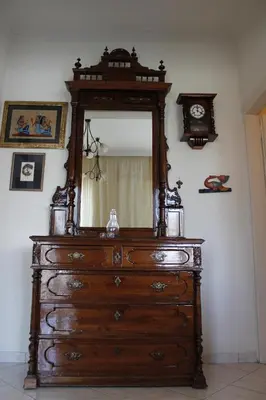 a wooden dresser with a mirror and a clock at Central luxurious Apartment with sea view! in Chania Town
