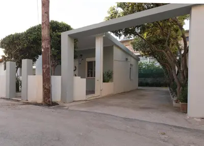 a white building with an archway in a parking lot at Cityscape House in Chania Town