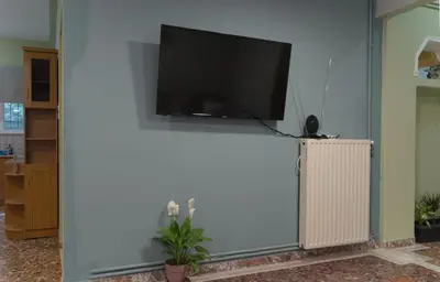 a flat screen tv hanging on a white wall at Cityscape House in Chania Town