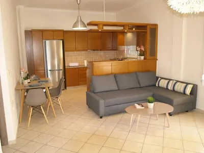 a living room with a couch and a kitchen at Urban Sea Apts in Chania Town