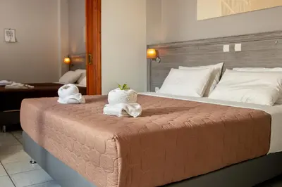 a bedroom with a large bed with towels on it at Anna Katerina Apartments in Plataniás
