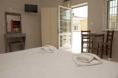 a bedroom with a white bed with two towels on it at Anna Katerina Apartments in Plataniás
