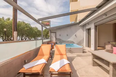 a balcony with orange chairs and a swimming pool at UTOPIA luxury apartment in Chania Town