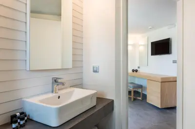 a bathroom with a white sink and a desk at Stellina Village in Kato Daratso