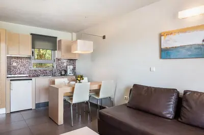 a living room with a couch and a table and a kitchen at Stellina Village in Kato Daratso
