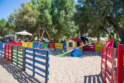 a playground with colorful playground equipment in the sand at Kalyves Beach Hotel in Kalyves