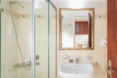 a bathroom with a sink and a shower with a mirror at Sevach Apartments in Kalamaki Chanion