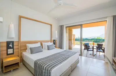 a bedroom with a large bed and a balcony at Kiani Beach Resort Family All Inclusive in Kalyves