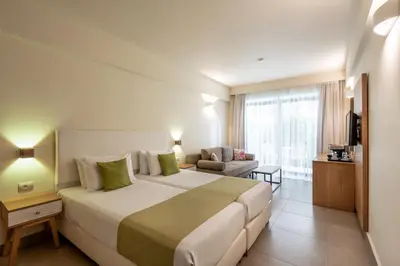 a hotel room with a large bed and a couch at Airis Boutique Hotel & Suites - For adults only in Kato Daratso