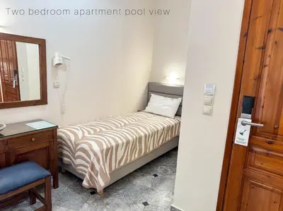 a small bedroom with a bed and a mirror at Ariadne Beach in Plataniás
