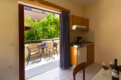 a kitchen and a balcony with a table and chairs at Ariadne Beach in Plataniás