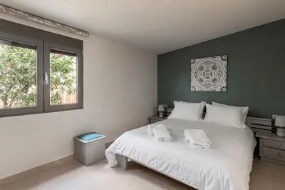 a bedroom with a white bed with two towels on it at Antonia Blue Villa in Mourniaí
