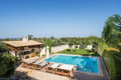 an outdoor swimming pool with chairs and a gazebo at Antonia Blue Villa in Mourniaí