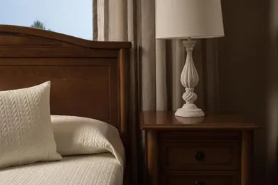 a lamp on a night stand next to a bed at Villa Ira in Chorafakia