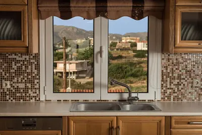 a kitchen with a sink and a window at Villa Ira in Chorafakia