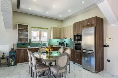 a kitchen with a table and chairs and a refrigerator at Elegant 2BR Apartment in Chania Town