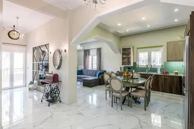 a kitchen and living room with a table and chairs at Elegant 2BR Apartment in Chania Town