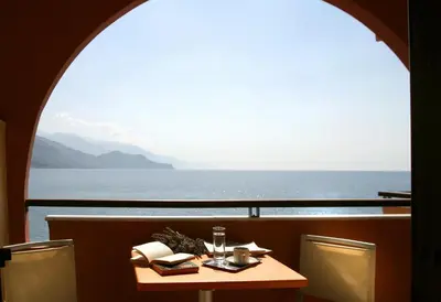 a table with a view of the ocean from a ship at On The Rocks in Palaiochóra