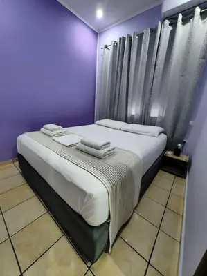 a purple bedroom with two beds with towels on them at Nina Apartment in Chania Town