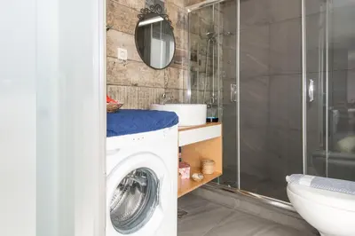 a bathroom with a washing machine and a mirror at You and Me -750m from the sea in Kissamos