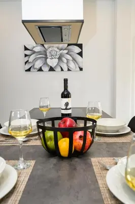 a table with a bowl of fruit and a bottle of wine at Modern Spacious Apartment in Kissamos