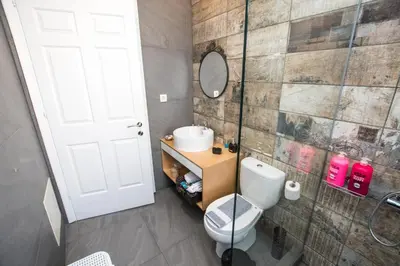 a bathroom with a toilet and a sink and a mirror at Modern Spacious Apartment in Kissamos