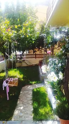 a garden with a swing and some flowers at Irtakina in Sougia