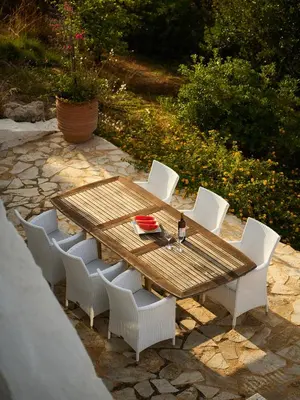 a wooden table with white chairs and a bottle of wine at Villa Anton by Cura Villas Collection in Kalathas