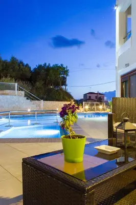 a table with a vase on it next to a pool at Esthisis Suites Chania in Plataniás