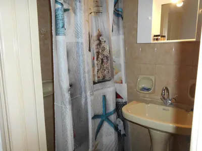 a bathroom with a shower curtain with a sink at Ilona Apartments Chania in Kato Daratso