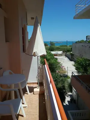 a balcony with an umbrella and a table and chairs at Ilona Apartments Chania in Kato Daratso