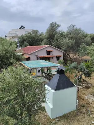 a house with a blue roof and a building at Olea Cottage in Galatás