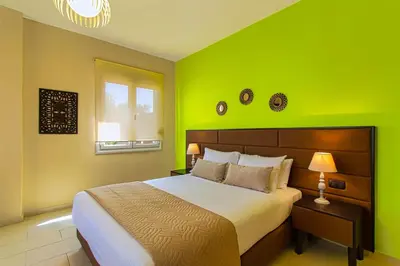 a green bedroom with a bed and a window at Theo Villas With Sea View in Marathokefála