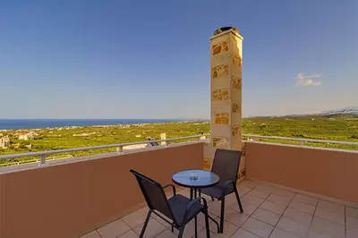 a balcony with a table and chairs and the ocean at Theo Villas With Sea View in Marathokefála