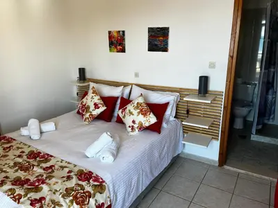 a bedroom with a large bed with red pillows at Michael Apartments in Agia Marina Nea Kydonias