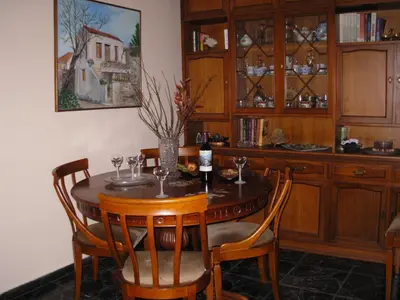 a dining room table with chairs and a bottle of wine at Michele's Flat in Chania Town