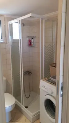 a bathroom with a shower and a washing machine at Amazing Sea View Apartment in Chania Town