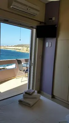 a room with a bed and a view of the ocean at Amazing Sea View Apartment in Chania Town