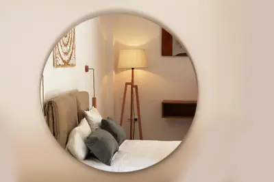 a bedroom with a bed and a mirror at Deluxe Hotel in Chania Town