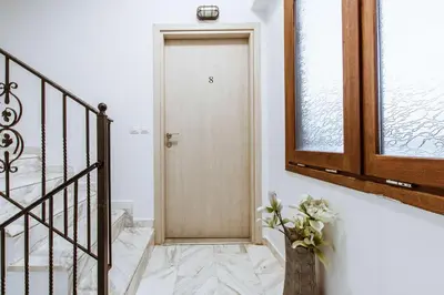 a hallway with a door and a vase with flowers at Deluxe Hotel in Chania Town
