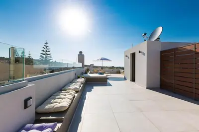 a balcony of a house with a view of the ocean at Villa Amelia I Free 8 seater mini van & pool in Kalathas