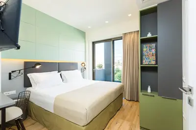 a hotel room with a bed and a desk and a window at Villa Amelia I Free 8 seater mini van & pool in Kalathas